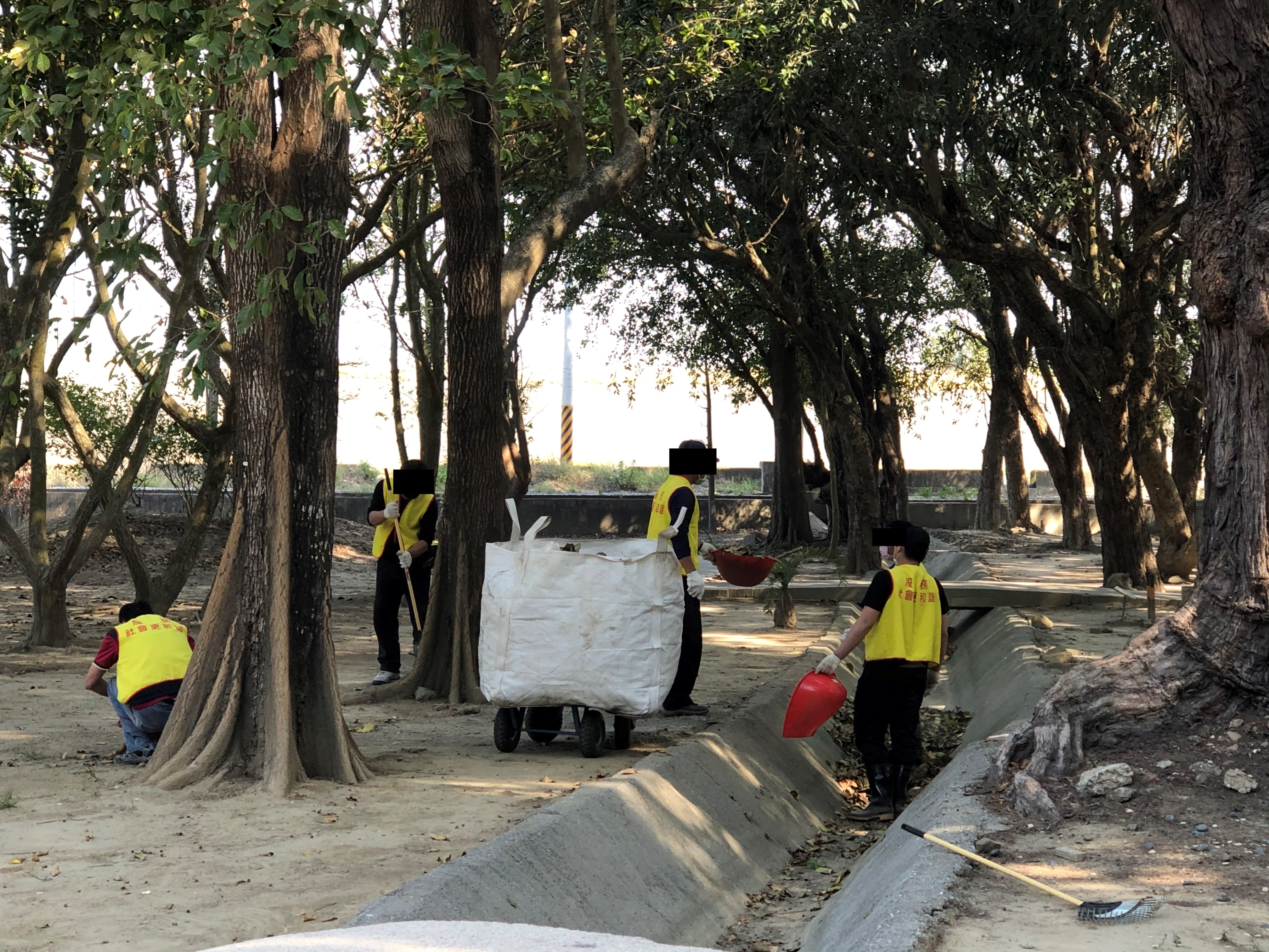 社會勞動人清掃藝術公園內水溝中的落葉、垃圾。