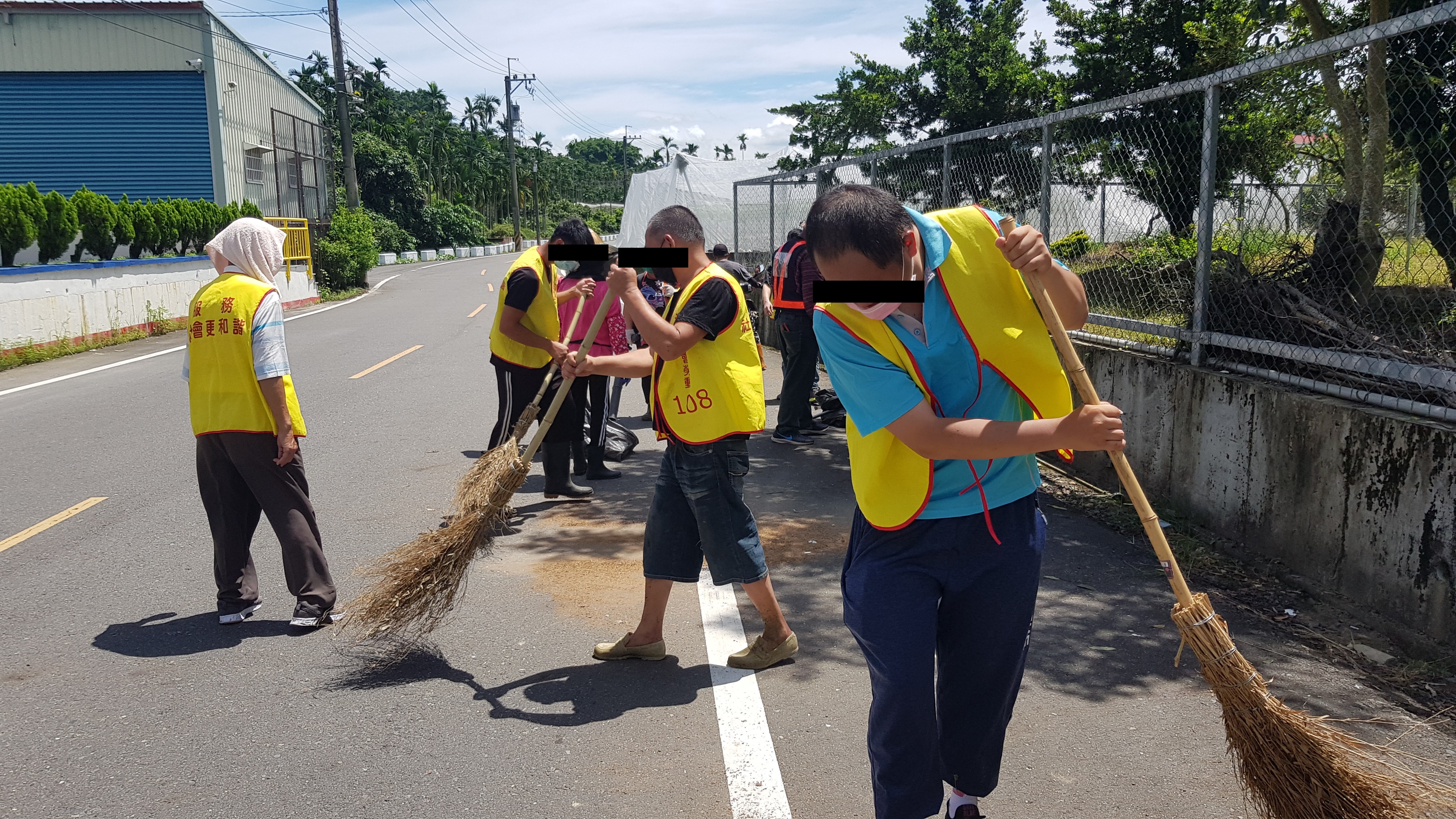 10.勞動人在社區主要道路上揮汗清掃。