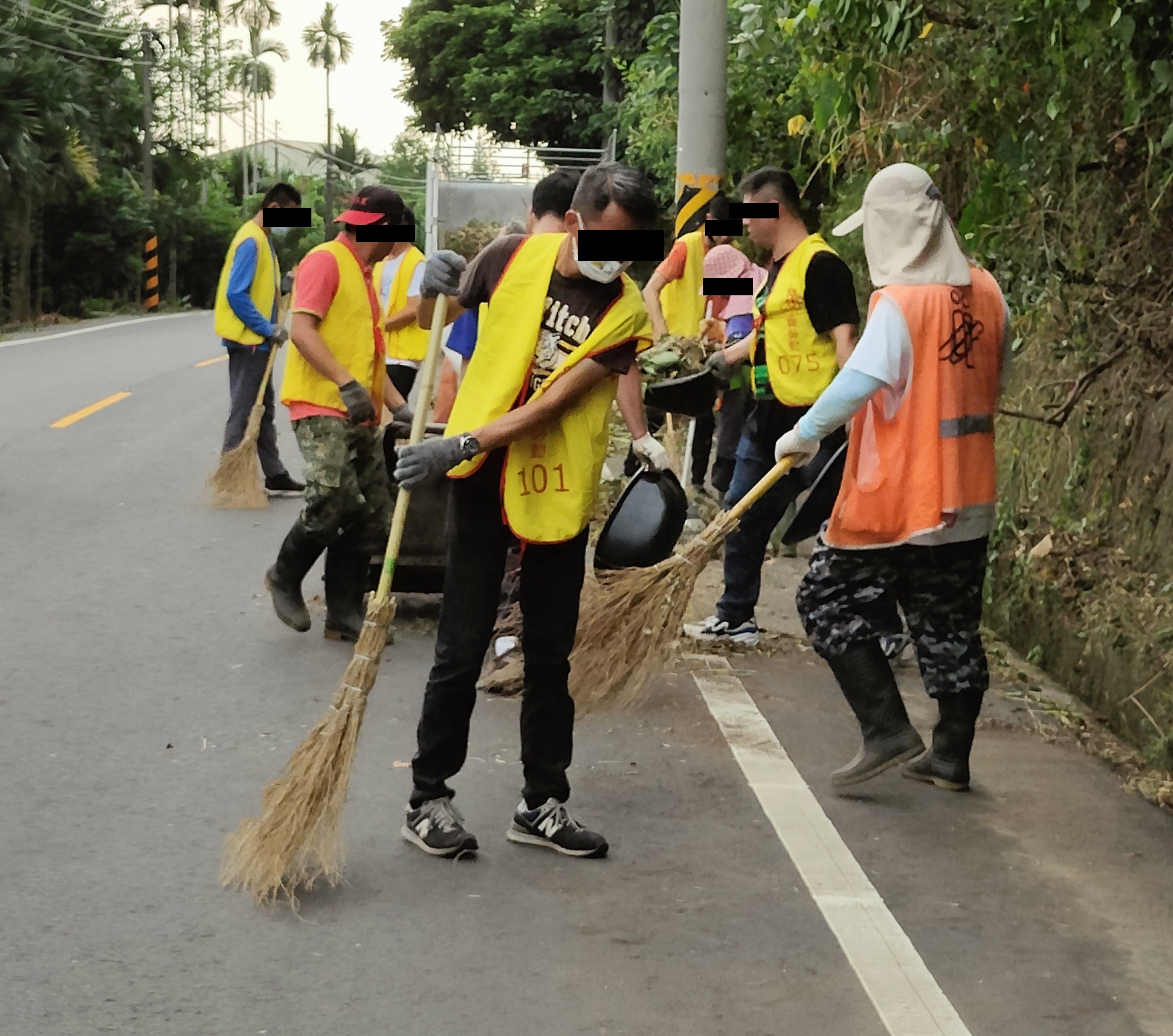 8.勞動人合力將路邊灰塵掃除。