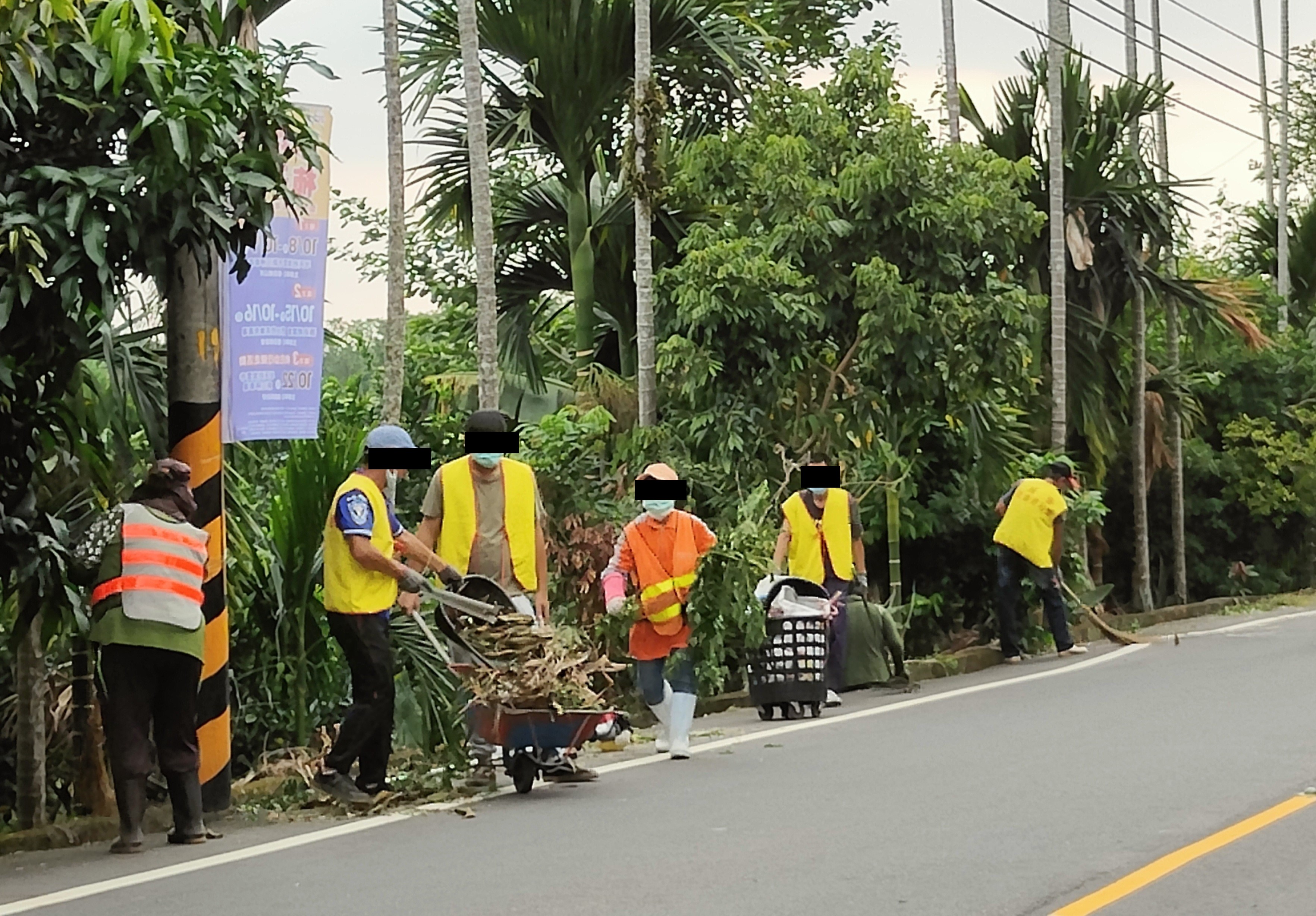 9.勞動人們合力將路旁的枯葉、垃圾搬運。