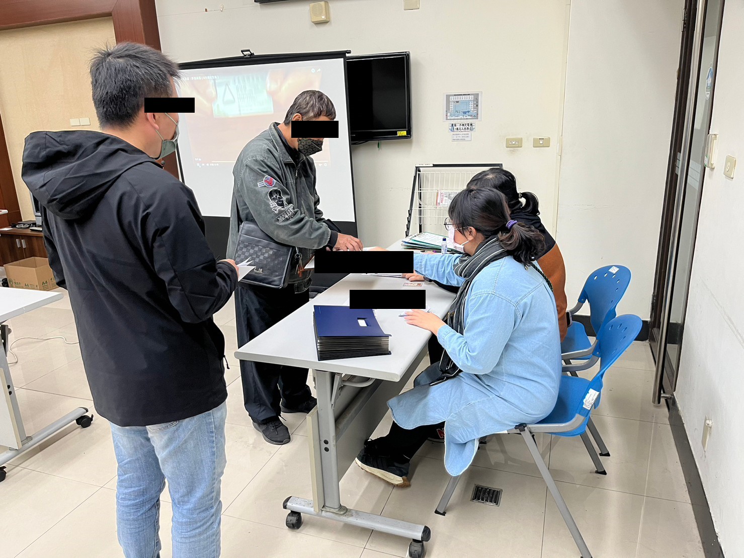 112.01.18-5.學員依序排隊等待報到，觀護佐理員細心協助相關資料之填寫。