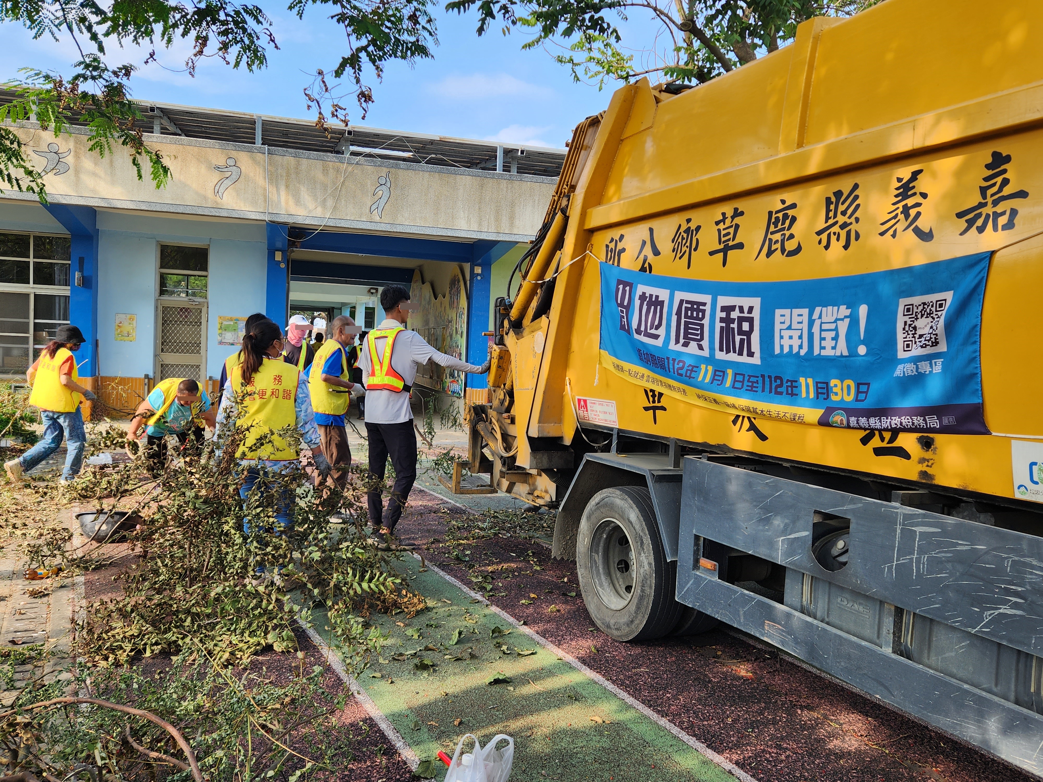 09.勞動人在碧潭國小操場清掃落葉及枯枝，並送至回收車上。