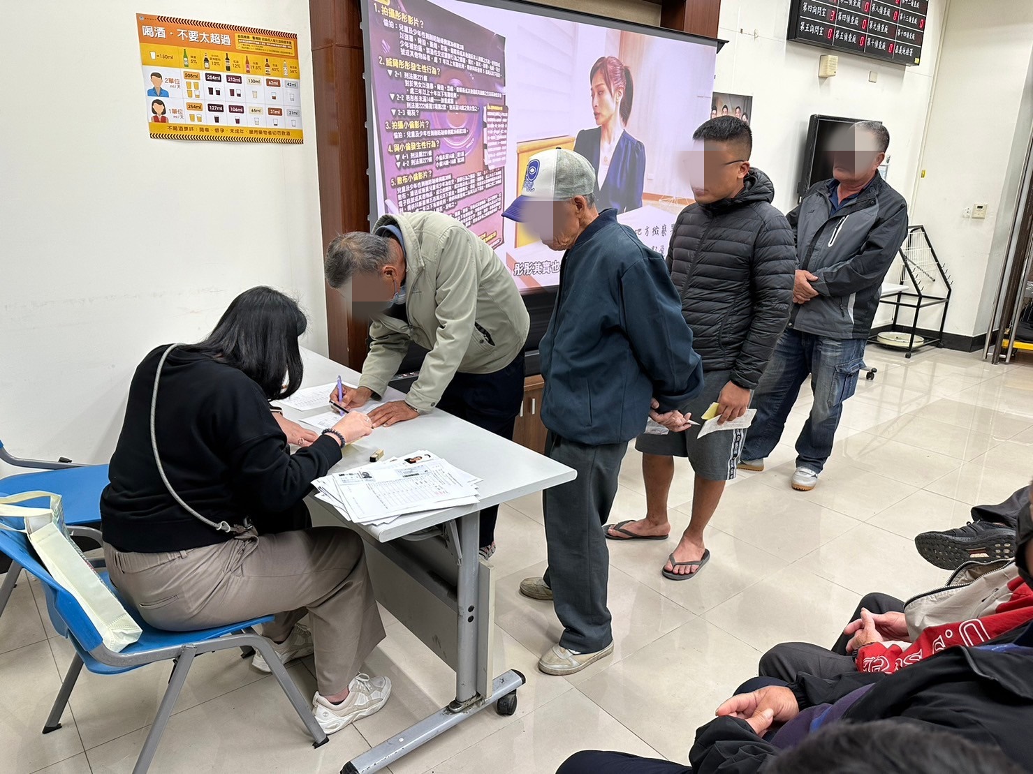 1130124-5.學員依序排隊等待報到，觀護佐理員細心協助相關資料之填寫。