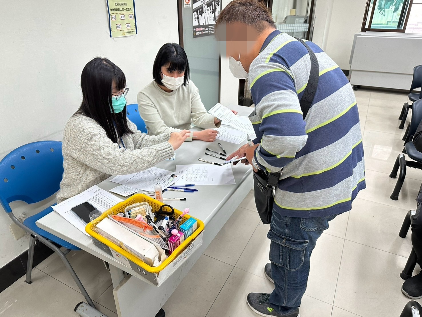 1140319-6.學員依序排隊等待報到，助理們細心協助相關資料之填
