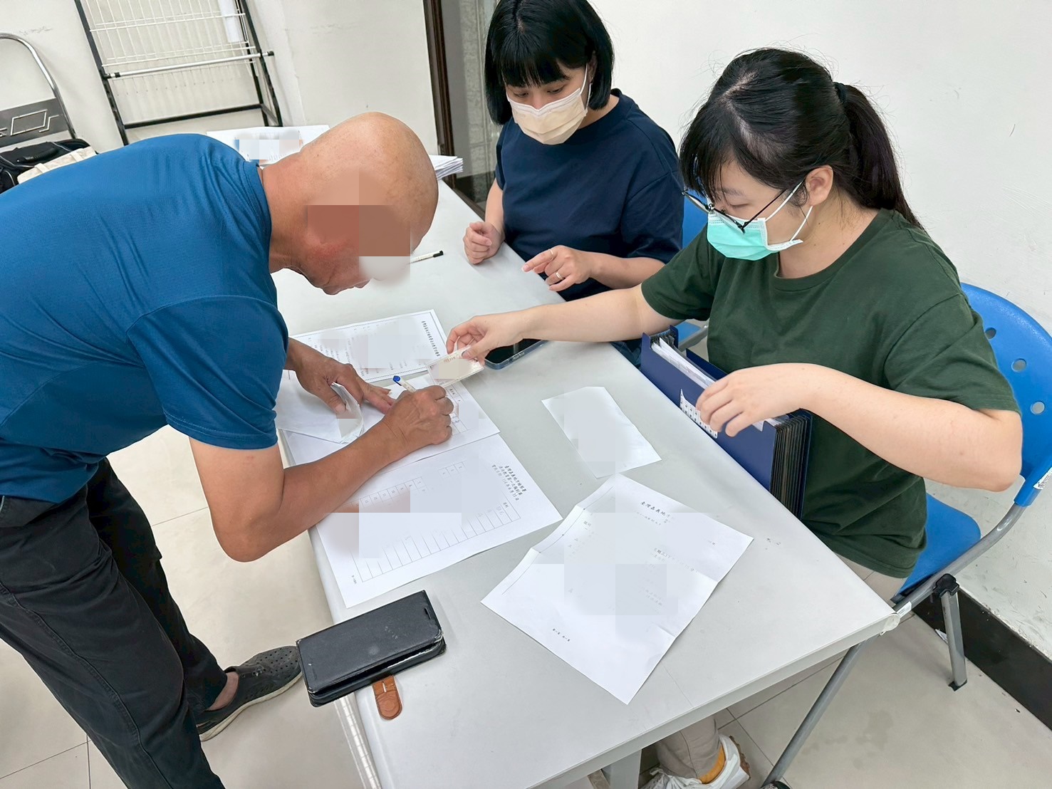1140611-2.學員依序排隊等待報到，助理們細心協助相關資料之填寫