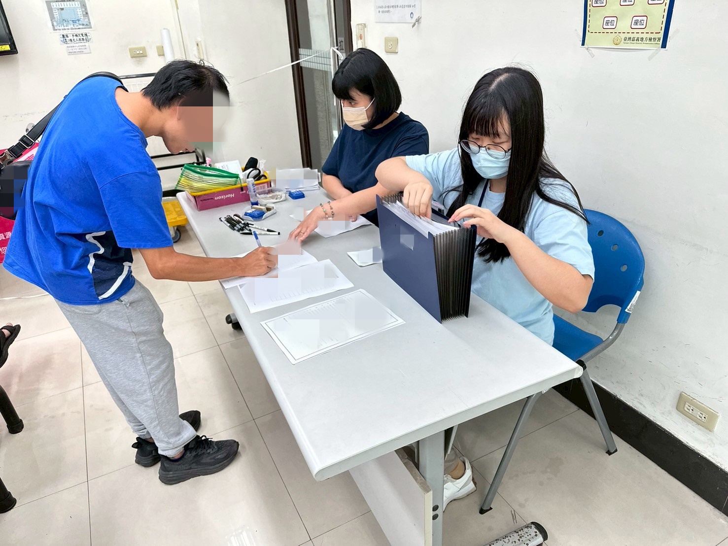 1140806-2.學員依序排隊等待報到，助理們細心協助相關資料之填寫