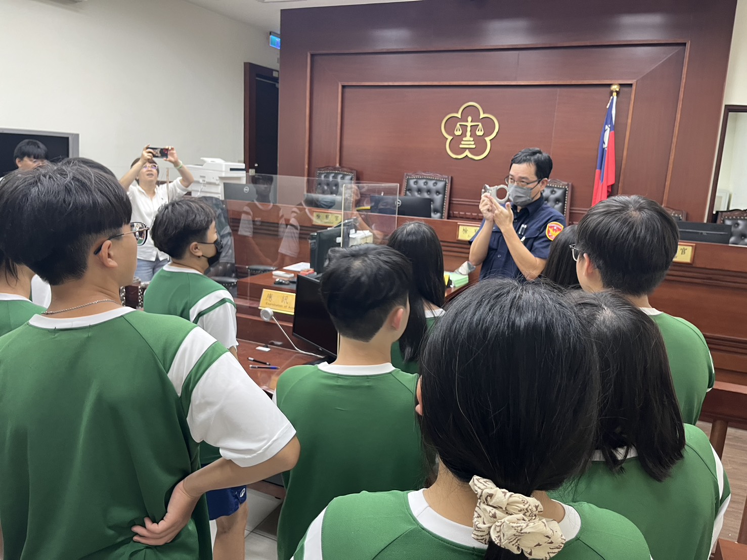 本署副法警長帶領師生依序踏入了平時只有在影劇中才能見到的偵查庭，親身感受莊嚴的審訊氛圍。