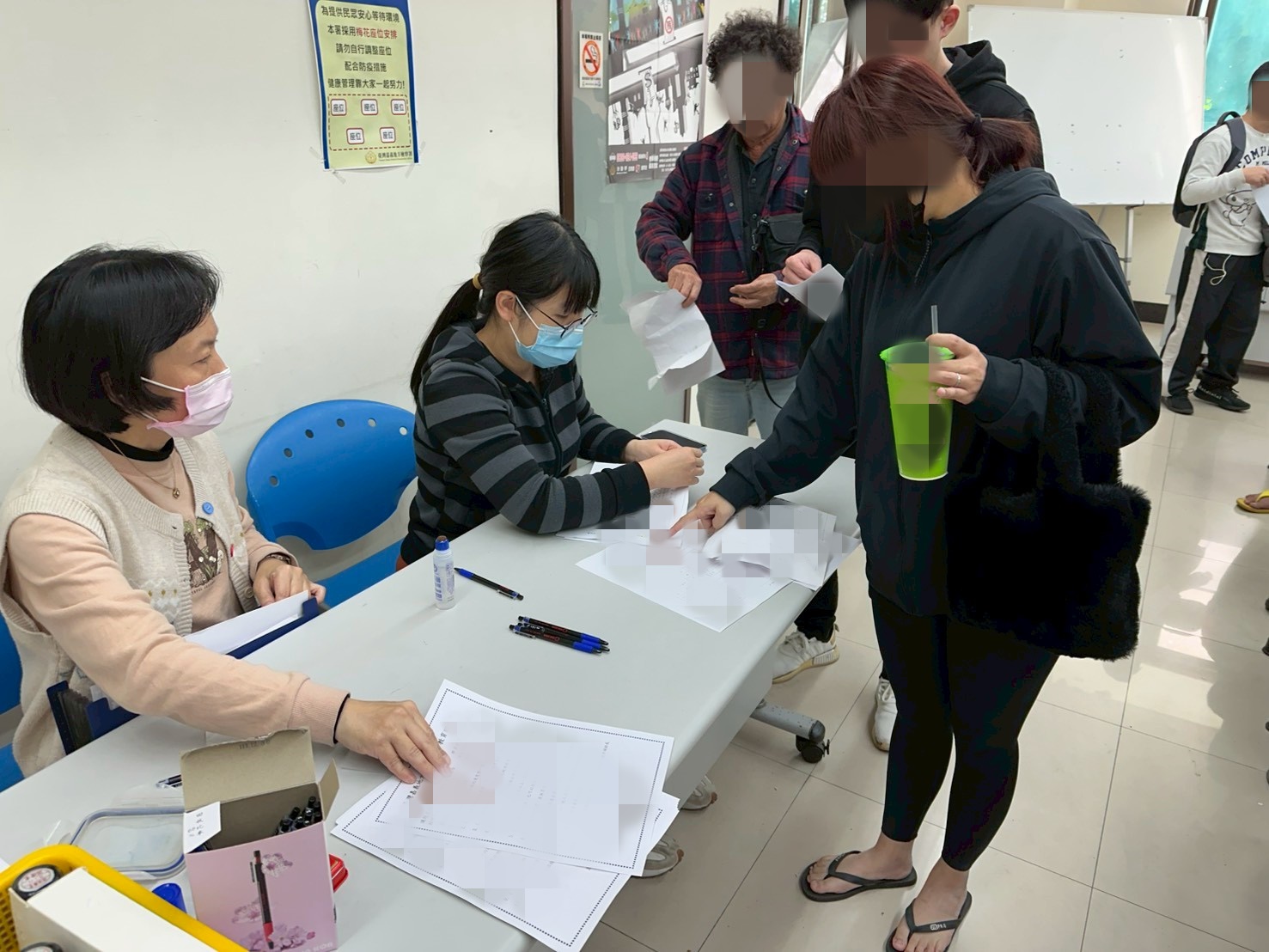 1150211-1.學員依序排隊等待報到，助理們細心協助相關資料之填寫