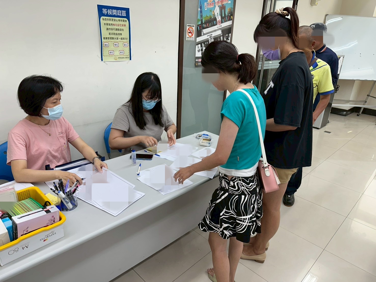 1150422-6.學員依序排隊等待報到，助理們細心協助相關資料之填寫