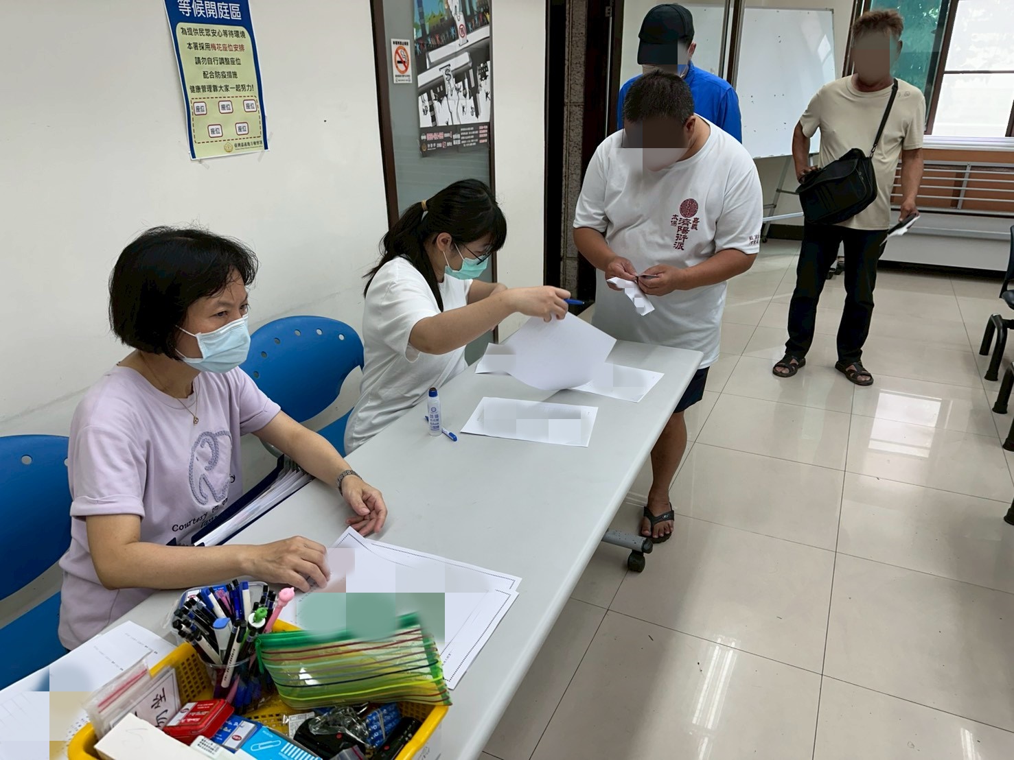1150624-6.學員依序排隊等待報到，助理們細心協助相關資料之填寫